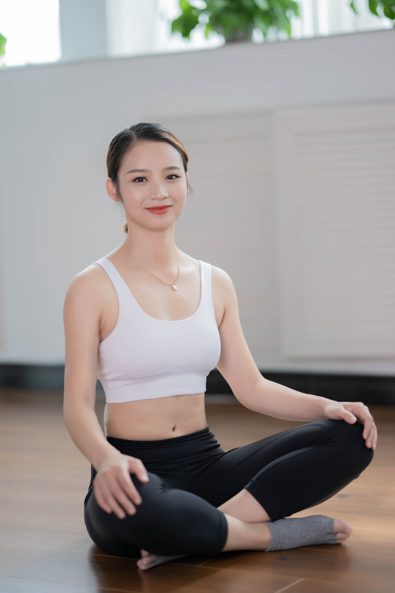 Woman in White Sports Bra and Black Leggings Sitting on Floor